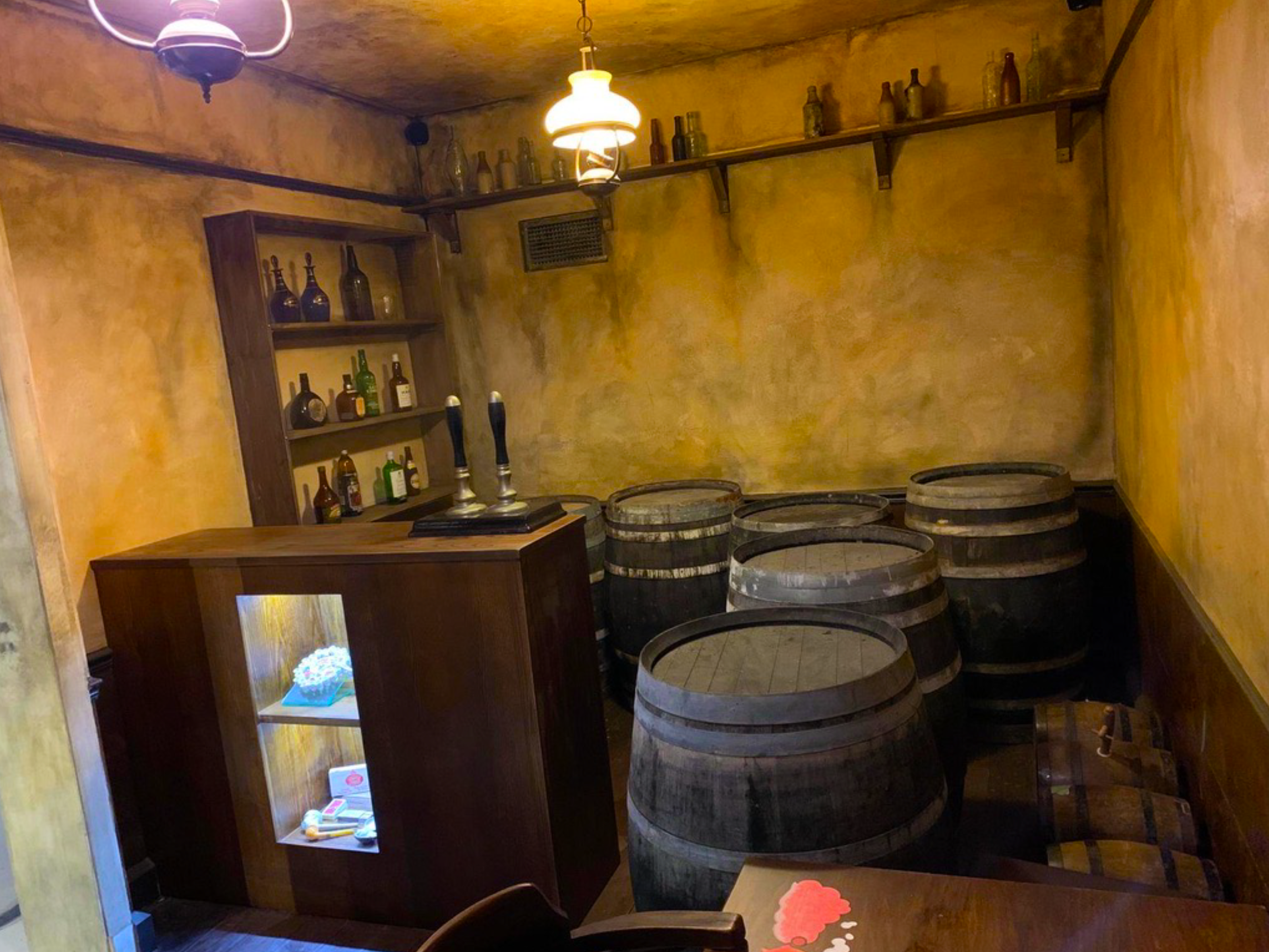 Bespoke fabric props recreating a vintage tavern scene, featuring handcrafted textile barrels, bottles, and bar elements. Custom soft props and fabric-built objects designed for museum displays, exhibitions, and immersive environments.